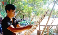 Joven étnico de Se Dang, apasionado por instrumentos musicales tradicionales