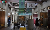 Mengunjungi museum alat pertanian di dekat jembatan yang beratap genting Thanh Toan