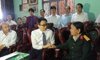  Deputi PM Vu Duc Dam memberikan bingkisan kepada keluarga yang mendapat kebijakan prioritas propinsi Kontum