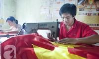 Keluarga yang menjahit Bendera Nasional Vietnam