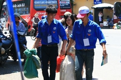Freiwillige Helfer in blauen Hemden bei der Hochschulaufnahmeprüfung