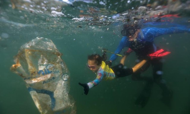 In Rio, a 4-year-old girl clears plastic waste from the ocean