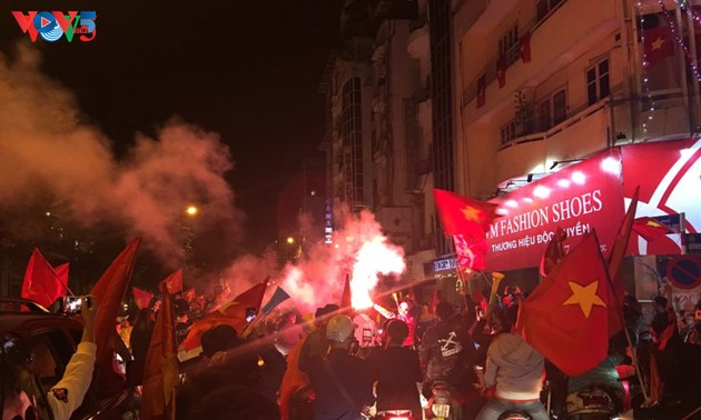 Hanoi streets covered in red flags, cheer football squad winning trophy