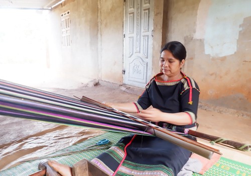 Una mujer teje en una máquina de tejer, trabajando con sus manos