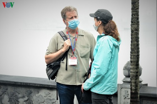 Иностранные туристы поддерживают правило надевать маски в общественных местах во Вьетнаме - ảnh 1