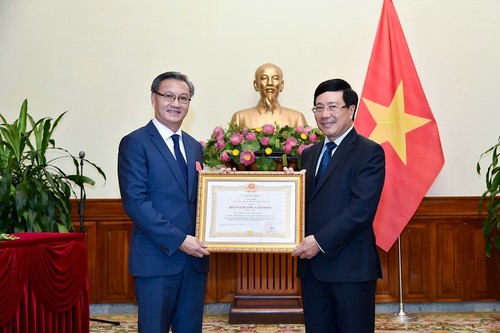 Deputi PM, Menlu Pham Binh Minh memberikan Bintang Jasa Kerja Kelas I kepada Dubes Laos di Vietnam - ảnh 1