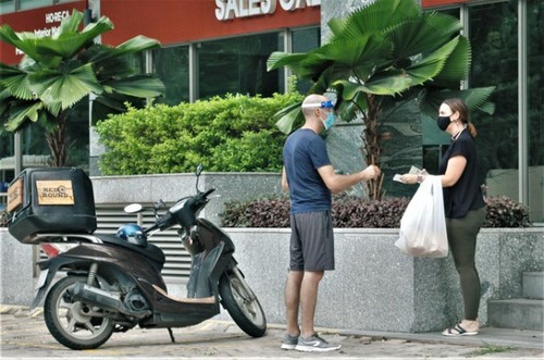 Foreigners follow social distancing rules in HCM City for COVID-19 fight - ảnh 9