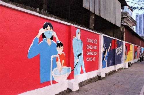 Les affiches sur la lutte anti-Covid-19 recouvrent les vieux murs de Hanoi - ảnh 1
