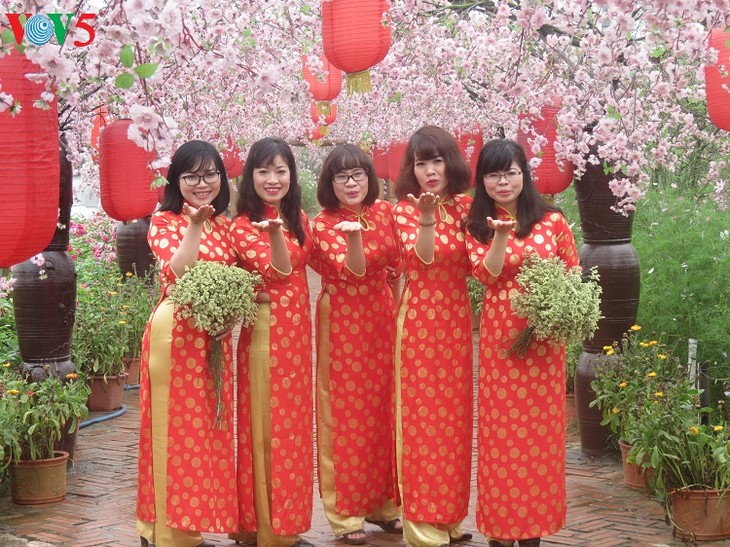 Les Vietnamiennes s’habillent en ao dài pour la fête du Têt - ảnh 3