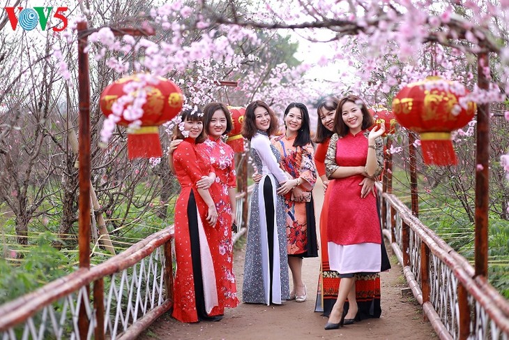 Les Vietnamiennes s’habillent en ao dài pour la fête du Têt - ảnh 11