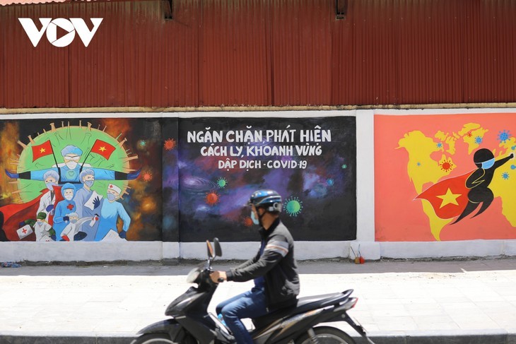 Keunikan Sudut Jalan Berhiaskan Mural Propaganda Pencegahan dan Penanggulangan Wabah Covid-19 di Kota Hanoi - ảnh 2
