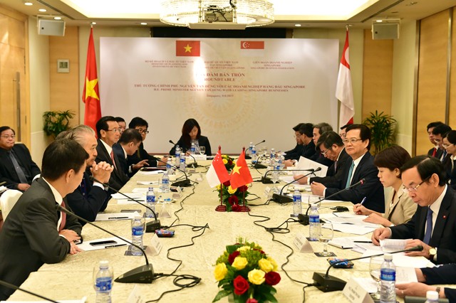 PM Nguyen Tan Dung tiba di Singapura dan melakukan pertemuan dengan komunitas orang Vietnam - ảnh 1