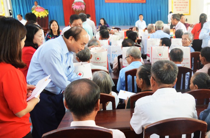 Premierminister Nguyen Xuan Phuc besucht Familien der verdienstvollen Menschen und Arbeiter in Tra Vinh - ảnh 1