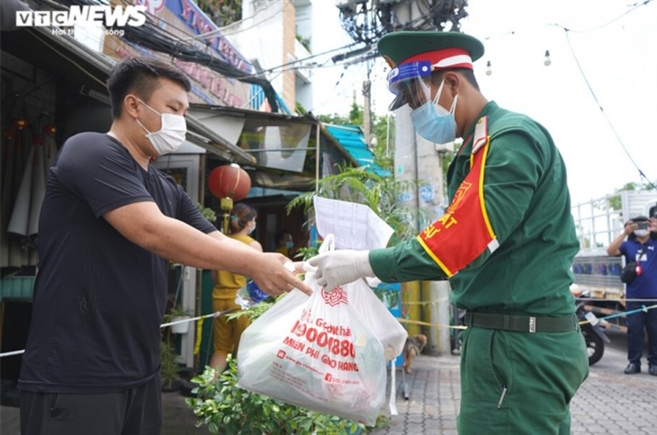 Military forces help locals shop amid tighter restrictions in HCM City - ảnh 13