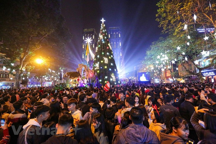 Vietnamitas en grandes ciudades disfrutan de una feliz Navidad - ảnh 1